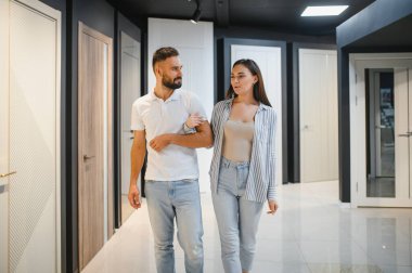 Hırdavatçıda alışveriş yapan genç adam ve kadının portresi farklı kapı seçenekleri seçiyor..