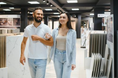 Genç evli çift evleri için fayans seçiyor..