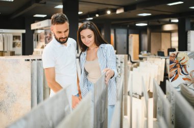 Evli çift mutfak için seramik fayanslar seçiyor ya da bir hırdavatçıda banyo yapıyor..