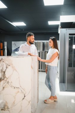 Mağazada yeni fayanslar seçen mutlu bayan müşteri. Genç bir kadın mutfağını yeniliyor. Yüksek kalite fotoğraf