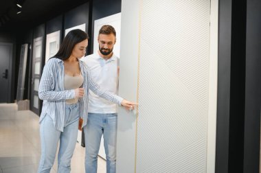 Genç bir çift yeni evleri için iç kapılar seçiyor.