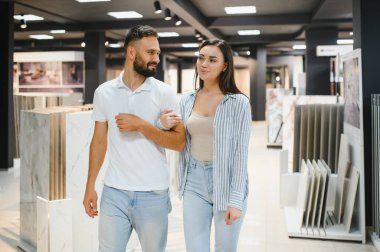 Evli çift mutfak için seramik fayanslar seçiyor ya da bir hırdavatçıda banyo yapıyor..