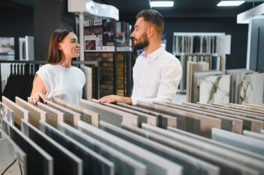 Satıcı ve bayan bir müşteri evi için seramik bir fayans seçiyorlar, ev tasarımı mağazasında..