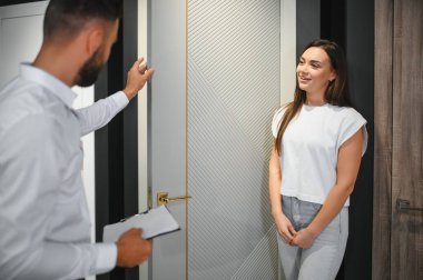 Genç bayan alıcı hırdavatçıdaki ahşap kapıyı seçiyor..