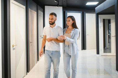 Hırdavatçıda alışveriş yapan genç adam ve kadının portresi farklı kapı seçenekleri seçiyor..