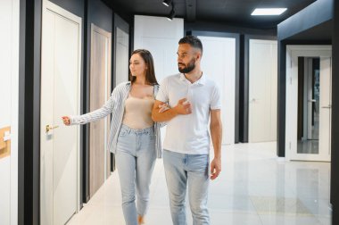 Evli bir çift, hırdavatçıdaki evleri için yeni iç kapılar seçiyor..