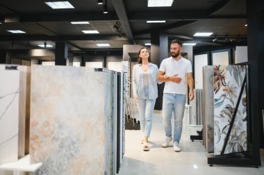 Evli çift mutfak için seramik fayanslar seçiyor ya da bir hırdavatçıda banyo yapıyor..