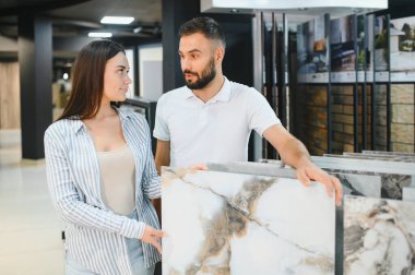 Evli çift mutfak için seramik fayanslar seçiyor ya da bir hırdavatçıda banyo yapıyor..
