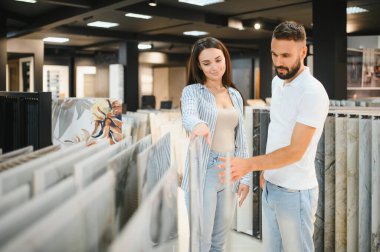 İnşaat pazarında fayans seçen genç çift.