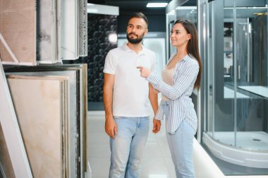 Evli çift mutfak için seramik fayanslar seçiyor ya da bir hırdavatçıda banyo yapıyor..