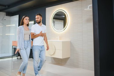 Banyodaki mobilya dükkanında lavaboyu seçen pozitif çift..