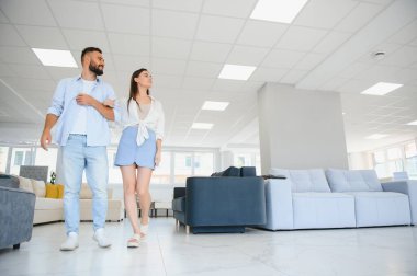 Evli çift mobilya mağazasındaki en iyi yeni kanepeyi seçiyor..