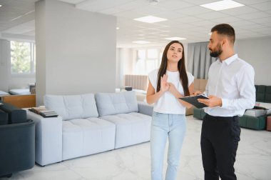 Satıcı, mobilya salonunda genç bir kadınla buluşuyor..