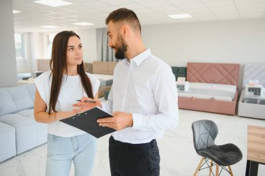 Satıcı, mobilya salonunda genç bir kadınla buluşuyor..