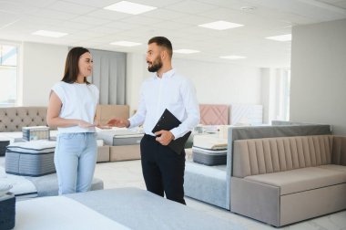 Profesyonel bir satış danışmanı bir mobilya mağazasında bir müşteriye tavsiyede bulunur