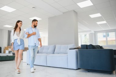 Evli çift mobilya mağazasındaki en iyi yeni kanepeyi seçiyor..