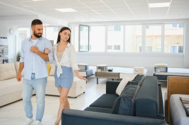 Çift mobilyaları mağazada döşemeyi seçiyor.