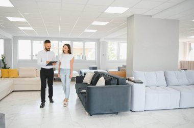 Satıcı, mobilya salonunda genç bir kadınla buluşuyor..