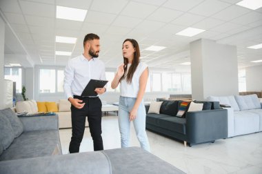 Satıcı, mobilya salonunda genç bir kadınla buluşuyor..