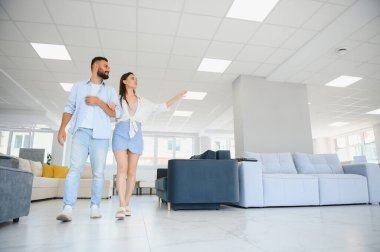 Çift mobilyaları mağazada döşemeyi seçiyor.