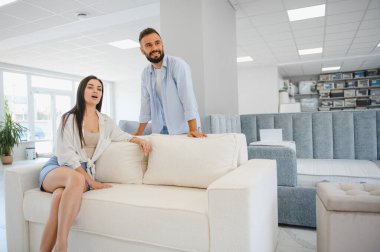 Çift mobilya dükkanında kanepe ve yastık seçiyor..