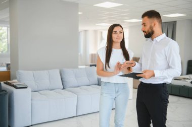 Profesyonel bir satış danışmanı bir mobilya mağazasında bir müşteriye tavsiyede bulunur