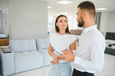 Satıcı, mobilya salonunda genç bir kadınla buluşuyor..