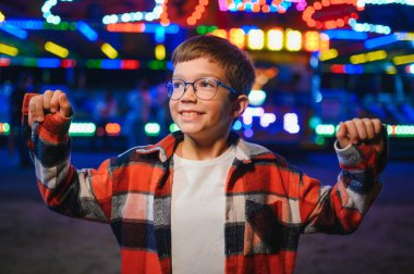 Yakışıklı ve mutlu bir çocuk lunaparkta eğleniyor..