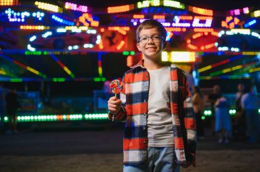 Mutlu çocukluk ve tatil kavramı. Sevimli bir çocuk eğlence parkında mutlu bir şekilde vakit geçirir..