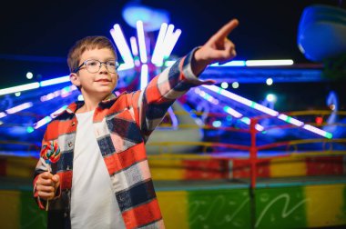 Mutlu çocukluk ve tatil kavramı. Sevimli bir çocuk eğlence parkında mutlu bir şekilde vakit geçirir..