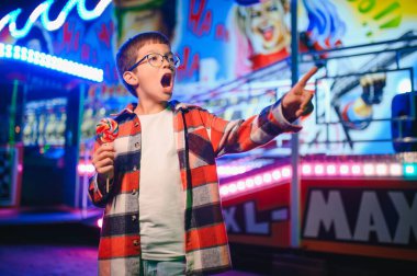 Yakışıklı ve mutlu bir çocuk lunaparkta eğleniyor..