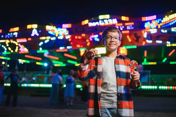 Yakışıklı ve mutlu bir çocuk lunaparkta eğleniyor..