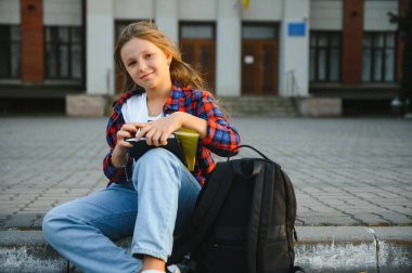 Sırt çantası ve kitapları olan güzel bir kız öğrenci. Okula geri dön..