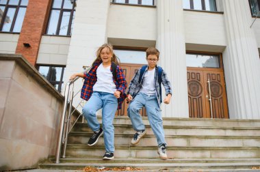 Okulun yakınındaki mutlu çocuklar. Okul bahçesinde kız ve erkek arkadaş..