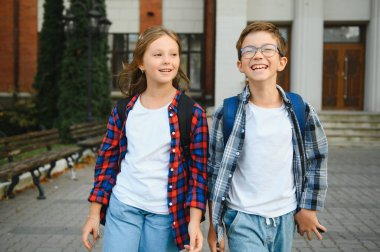 Okulun yakınındaki mutlu çocuklar. Okul bahçesinde kız ve erkek arkadaş..