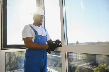 İnşaat alanındaki pencere kurulumunda çalışan erkek sanayi işçisi