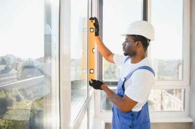 Ev üzerine beyaz plastik upvc pencere kurma işçisi.