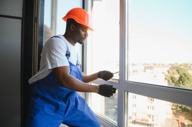 İnşaat alanındaki pencere kurulumunda çalışan erkek sanayi işçisi