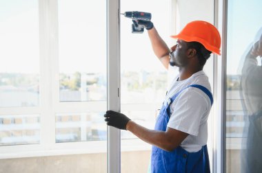 İçeriye plastik pencere kuran işçiler.