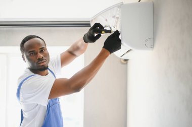 Mutlu genç Afrika erkek teknisyen Klima tamiri.