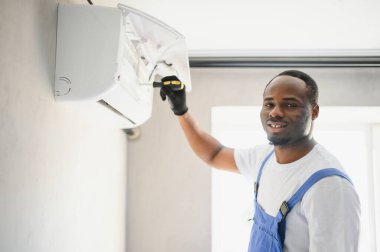 Mutlu genç Afrika erkek teknisyen Klima tamiri.