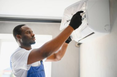 Mutlu genç Afrika erkek teknisyen Klima tamiri.