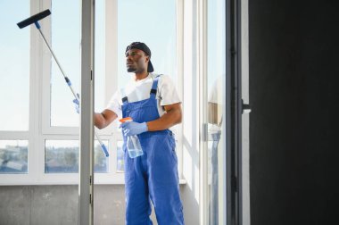 Pencereleri temizleyen bir adam. Erkekler camları siler..