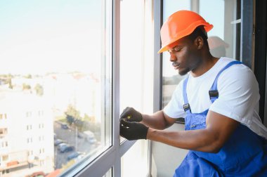 Ev üzerine beyaz plastik upvc pencere kurma işçisi.