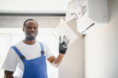 Mutlu genç Afrika erkek teknisyen Klima tamiri.