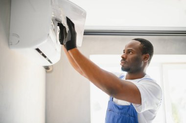 Mutlu genç Afrika erkek teknisyen Klima tamiri.