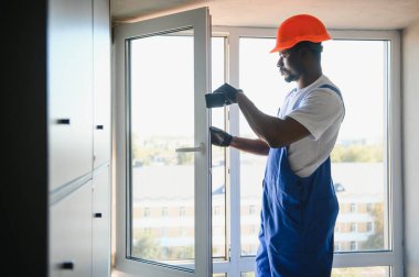 Ev üzerine beyaz plastik upvc pencere kurma işçisi.