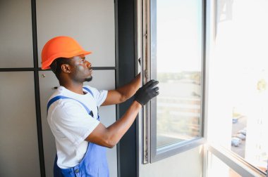 Ev üzerine beyaz plastik upvc pencere kurma işçisi.