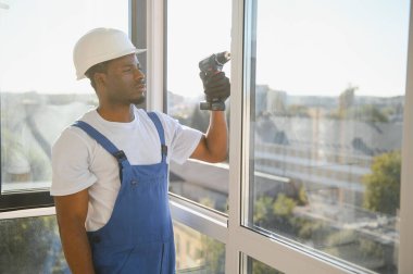 Ev üzerine beyaz plastik upvc pencere kurma işçisi.