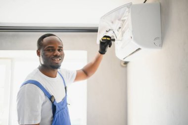 Mutlu genç Afrika erkek teknisyen Klima tamiri.